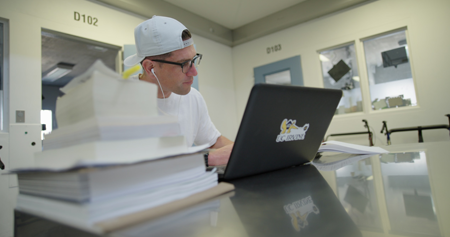 LIFTED student working on a laptop with a UCI sticker. 