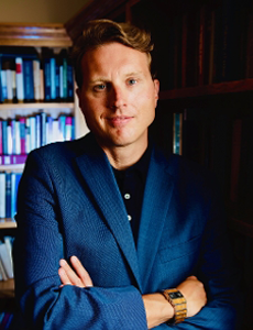 A photo of Professor Duncan Pritchard, standing in front of a bookshelf.