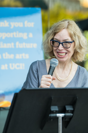 Julia Lupton standing at a podium with a microphone. 