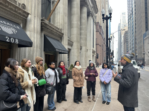 Students stand outside looking at architecture. 